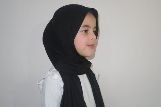 Kids wearing black jersey hijab on a plain background